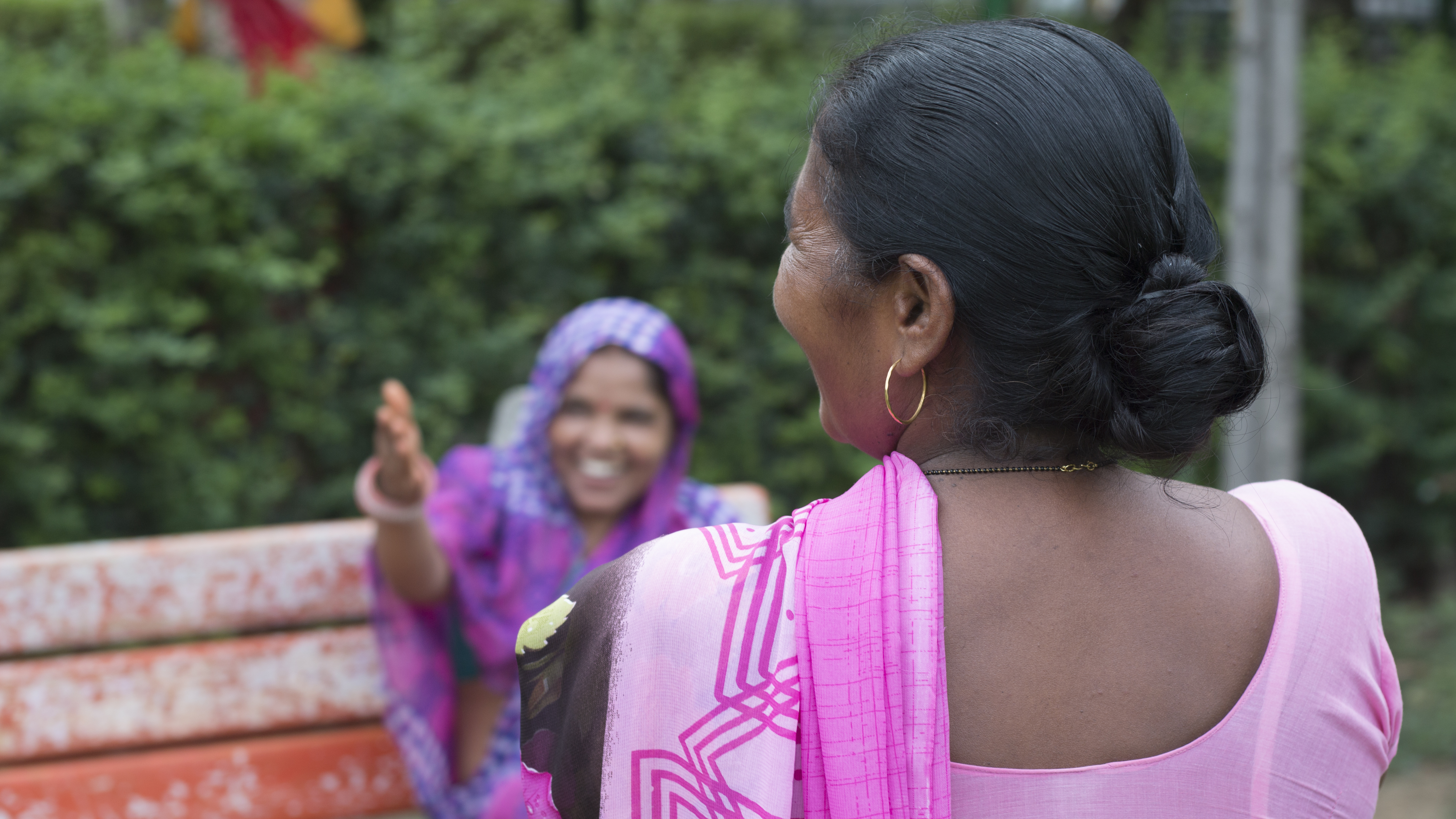 Two Indian women photographed, one sitting on a bench, telling their stories as part of this project